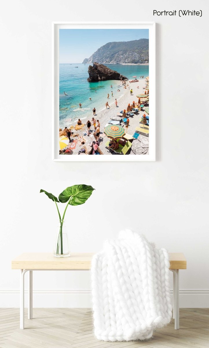 Big rock on Monterosso beach surrounded by people and blue water in Italy in a white fine art frame