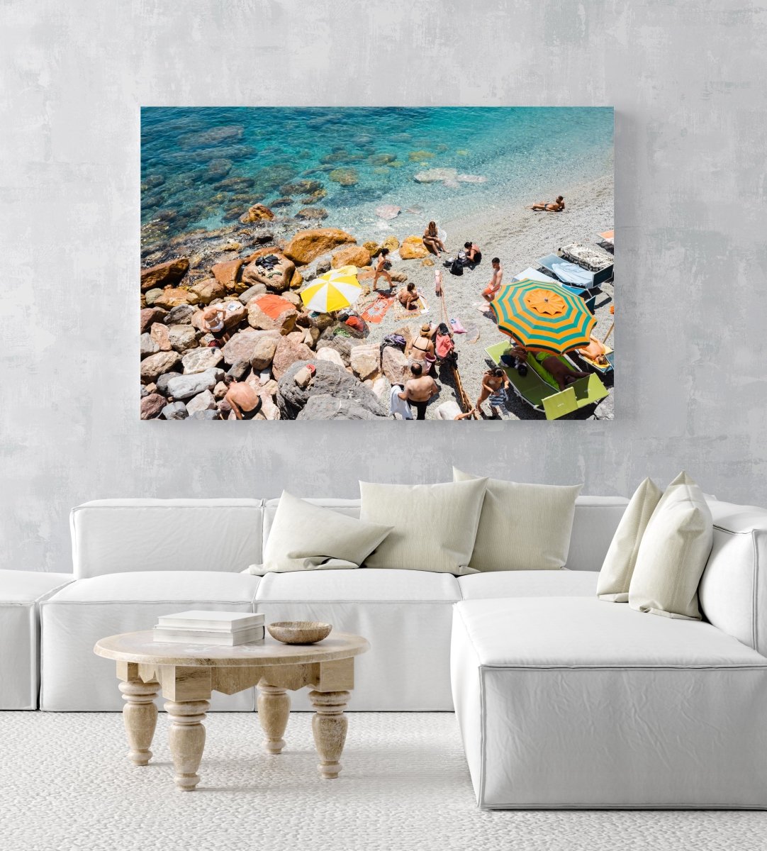 Umbrellas and people on beach with rocks and sand in Cinque Terre in an acrylic/perspex frame