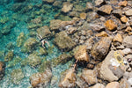 Two people swimming in clear blue water in Cinque Terre