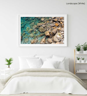 Two people swimming in clear blue water in Cinque Terre in a white fine art frame