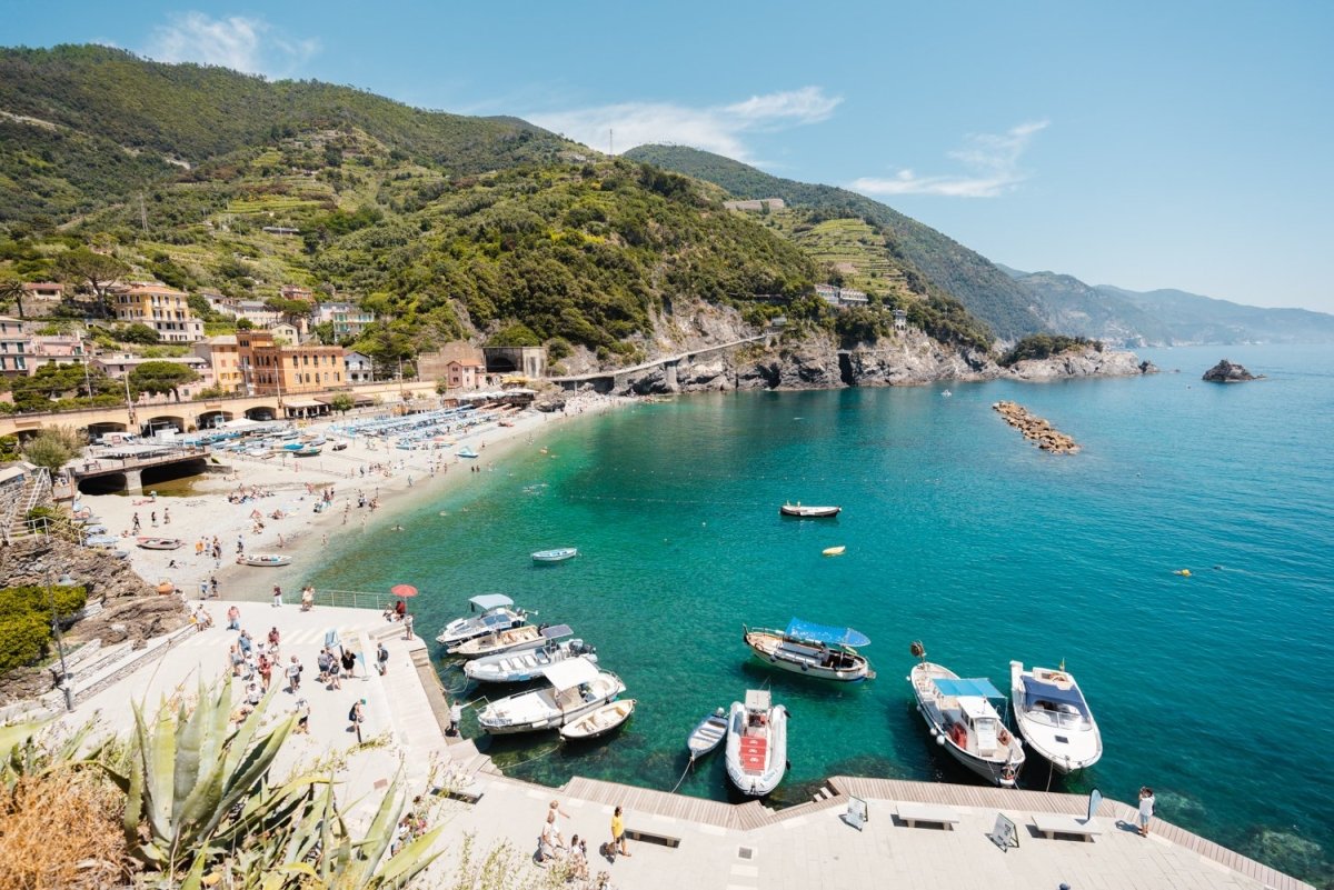 Boats docked along promenade of old town Monterosso during summer in Cinque Terre