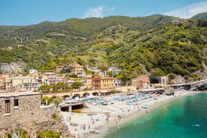 The old town of monterosso with people on beach and green hills