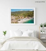 The old town of monterosso with people on beach and green hills in a white fine art frame