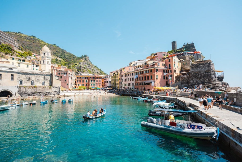People on boat in blue water in colorful Vernazza of Cinque Terre