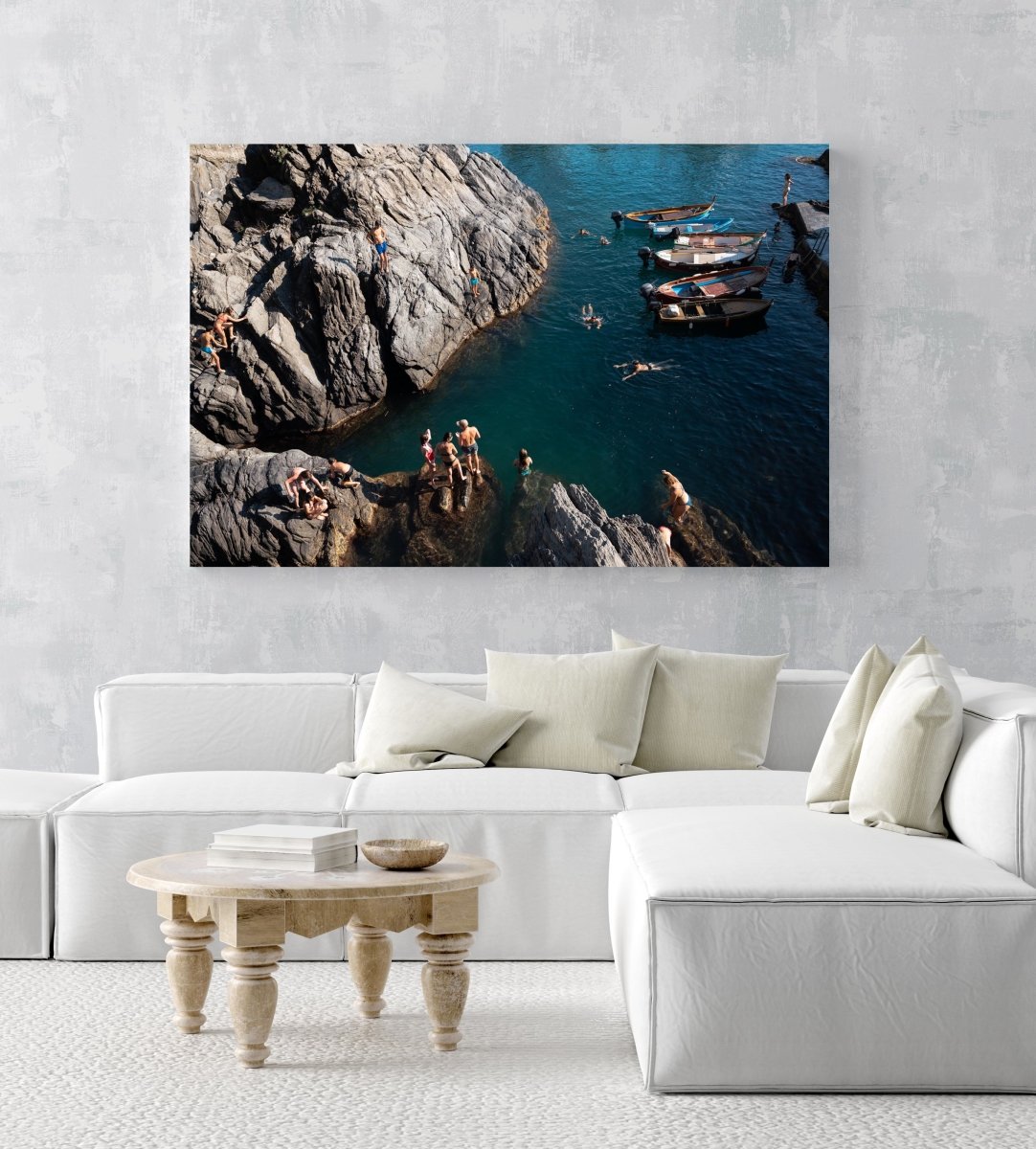 People swimming along dark rocks in Manarola Cinque Terre in an acrylic/perspex frame
