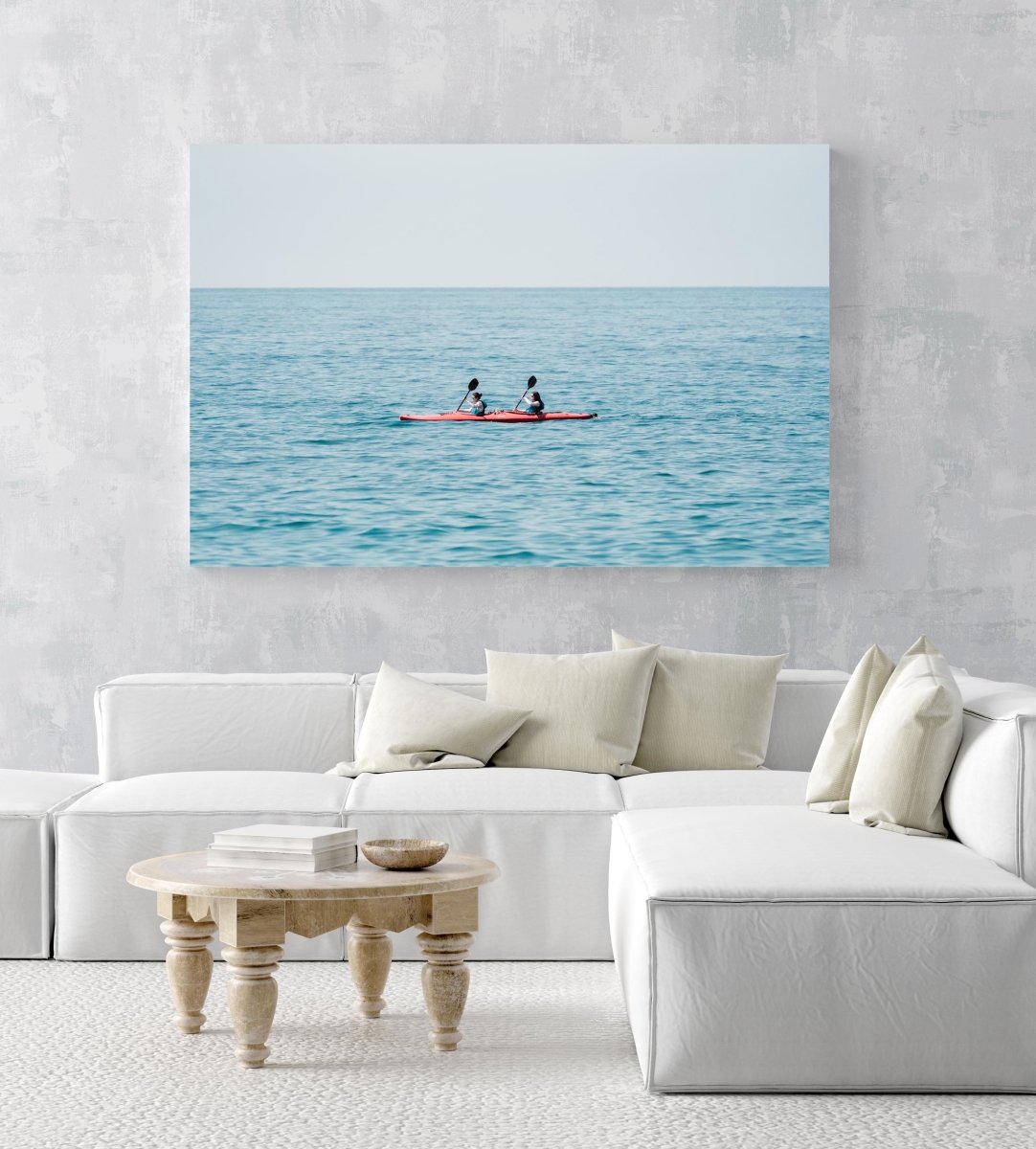 Two women paddling a red kayak in Cinque Terre in an acrylic/perspex frame