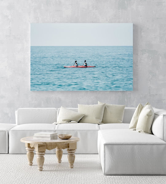 Two women paddling a red kayak in Cinque Terre in an acrylic/perspex frame