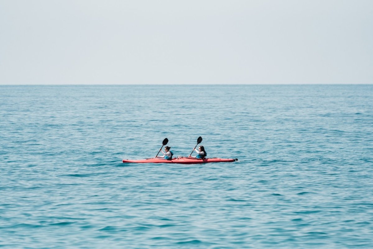 Two women paddling a red kayak in Cinque Terre