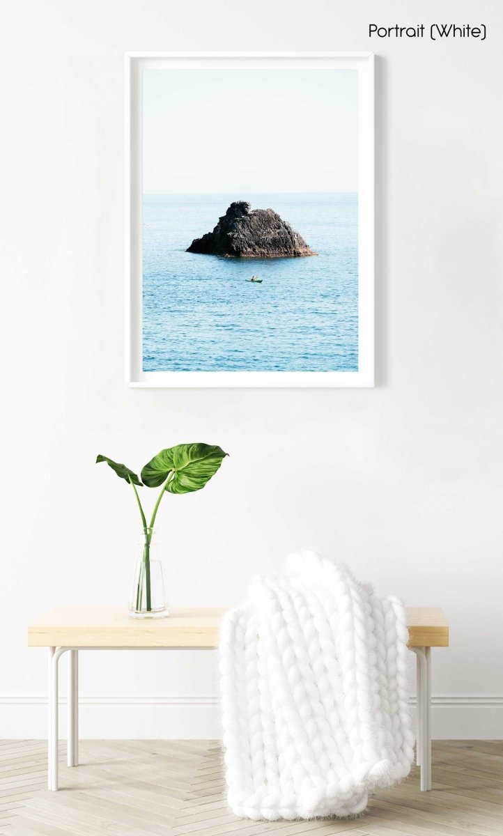 Man paddling in kayak at big rock in blue ocean in Cinque Terre in a white fine art frame