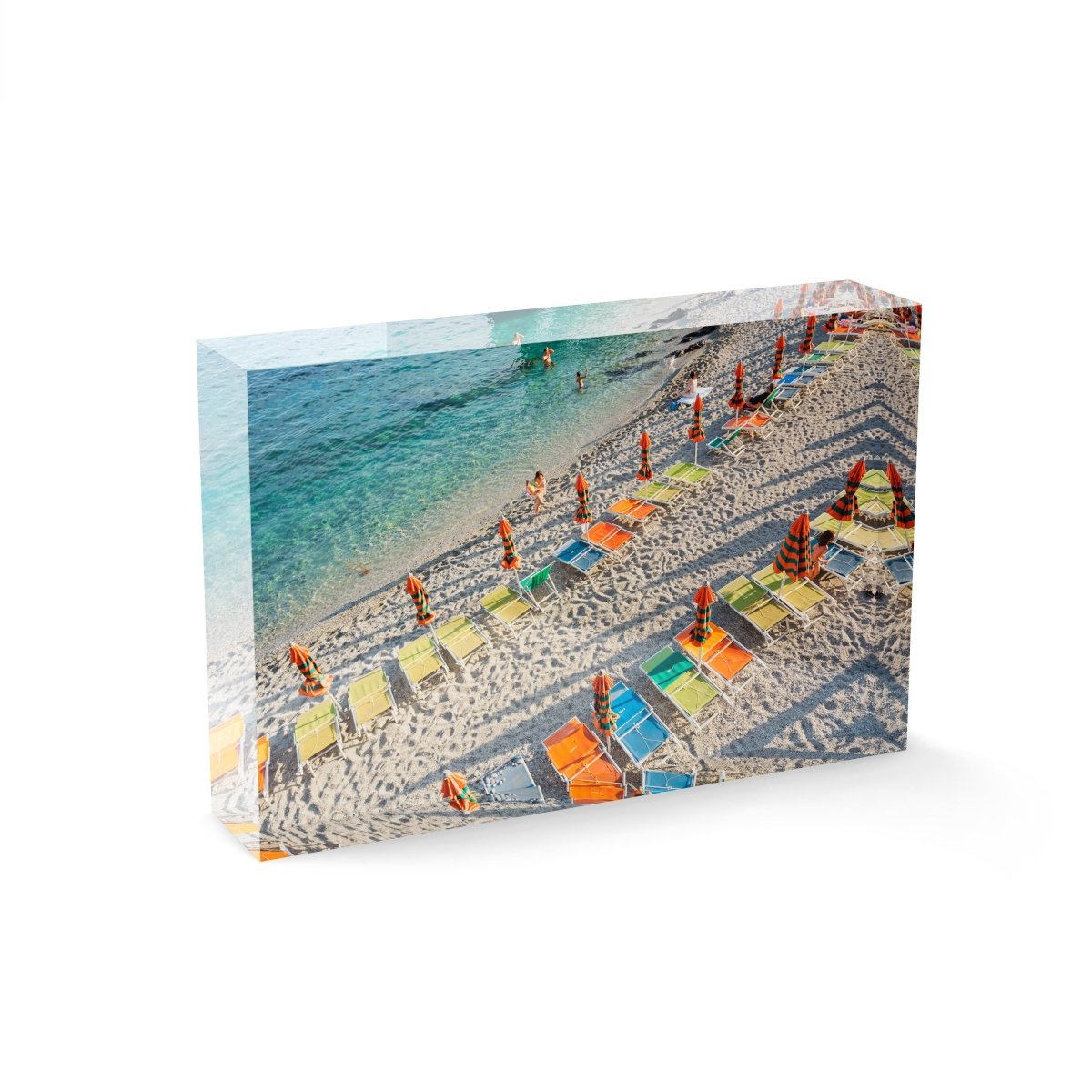 Orange, green and blue chairs on beach in Cinque Terre