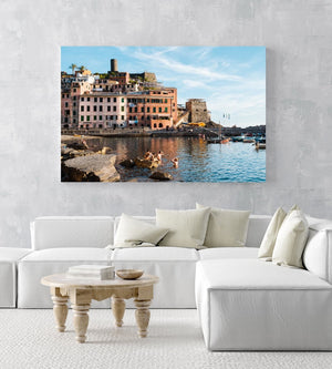 People swimming at Vernazza beach near buildings in an acrylic/perspex frame