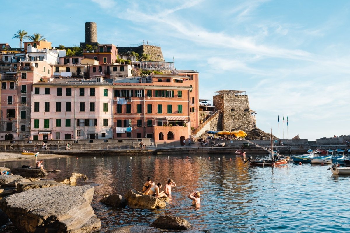 People swimming at Vernazza beach near buildings