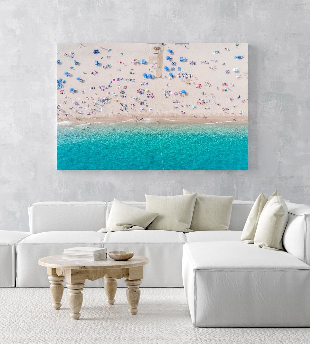 Aerial of blue ocean and people lying on Lloret de Mar beach in a natural fine art frame