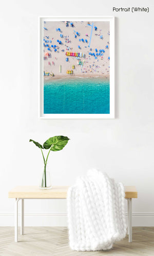 Colorful umbrellas, boats and water seen from air above Lloret de Mar beach in a white fine art frame