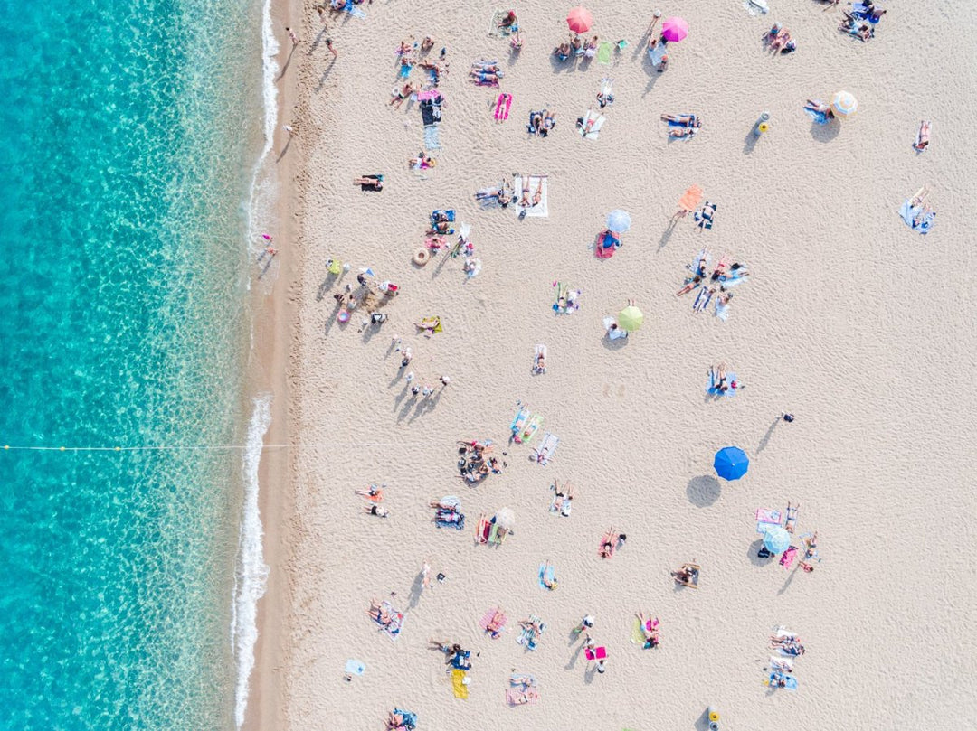 Busy beach day in Lloret de Mar during summer from aerial point