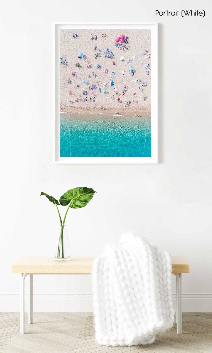 Topdown view of people lying on beach with bright blue water in Costa Brava in a white fine art frame