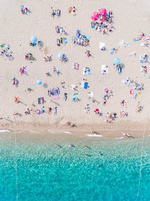 Topdown view of people lying on beach with bright blue water in Costa Brava