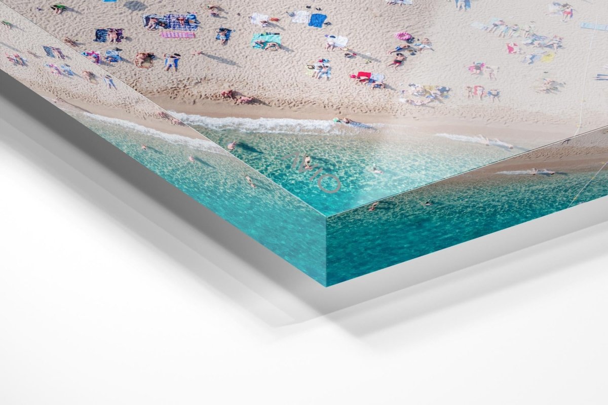 Aerial of people lying in the sun on the beach in an acrylic/perspex frame