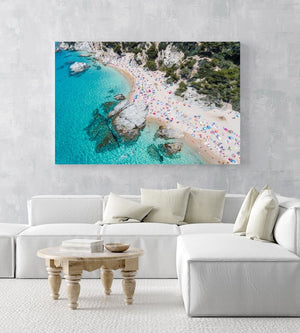 Aerial of bright blue sea, colorful umbrellas and people at Cala sa Boadella beach in an acrylic/perspex frame