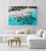 People swimming, snorkeling and tanning along blue water of spanish beach in an acrylic/perspex frame