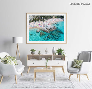 People swimming, snorkeling and tanning along blue water of spanish beach in a natural fine art frame