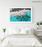 People swimming, snorkeling and tanning along blue water of spanish beach in a white fine art frame