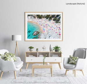 Colorful umbrellas and people lying on beach taken from the sky in a natural fine art frame