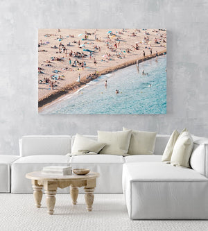 People lying on beach along calm blue sea in an acrylic/perspex frame