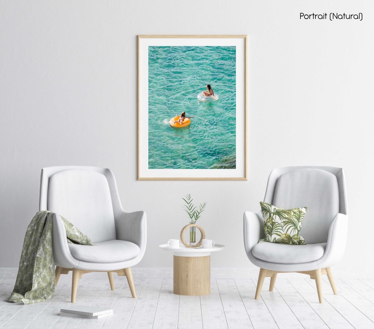 Young girl and woman floating on round lilos in turquoise sea in a natural fine art frame