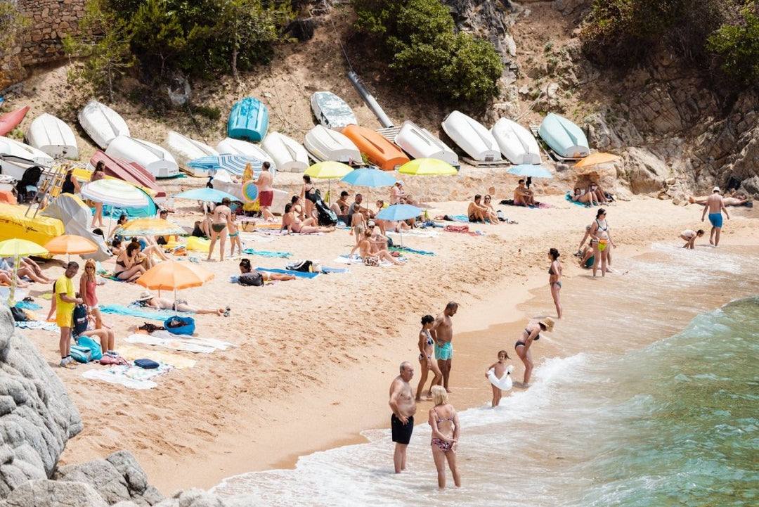 Colorful boats, umbrellas and people lying on beach