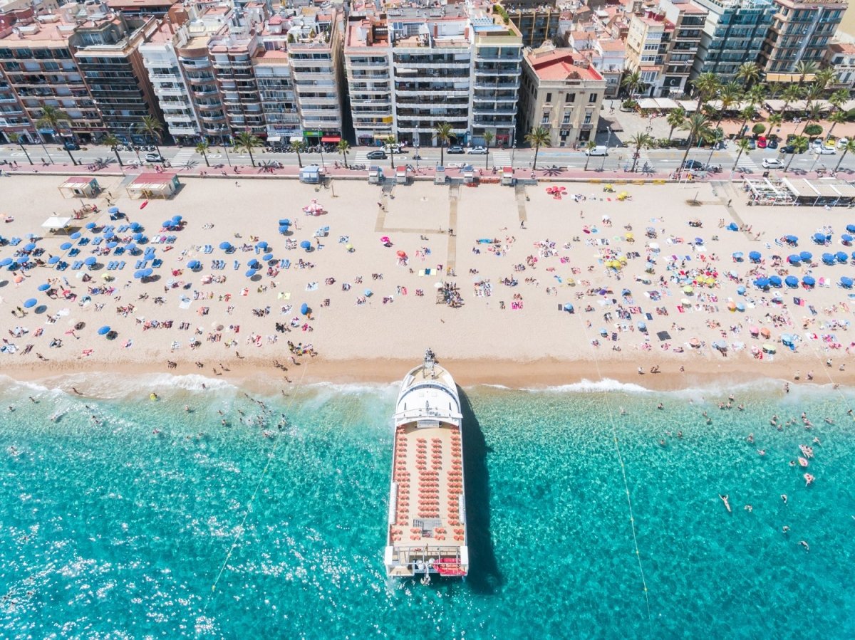 Big boat parked off on Lloret de Mar beach from above