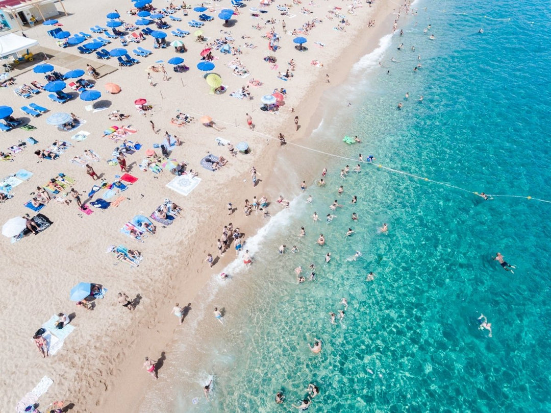 People swimming and having fun in blue water of Lloret de Mar