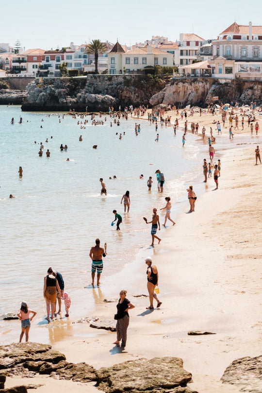 Lots of people along the water and beach in Cascais