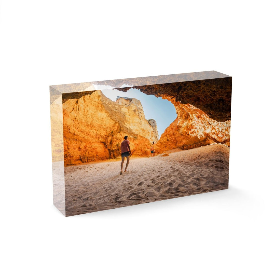 Man walking in a big yellow cave in Praia Dona Ana beach in Lagos