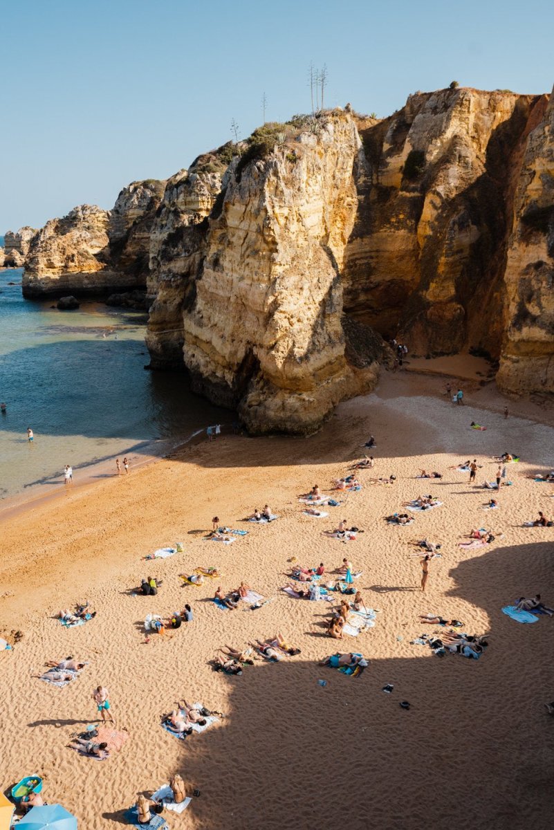 Shadows, cliffs and people on Praia Dona Ana in Lagos from above