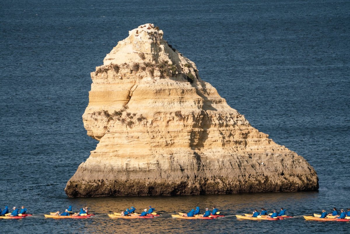 Many kayaks being towed in Lagos on a cave tour