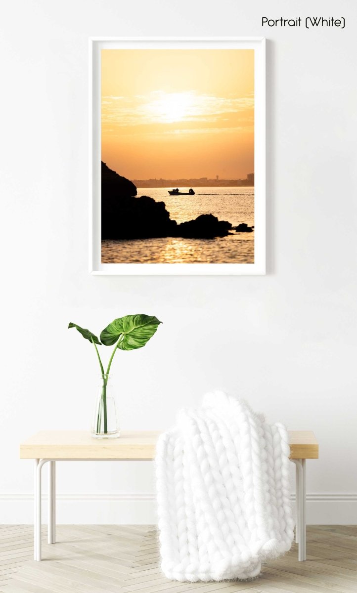 Orange sunrise with a boat cruising past Lagos coastline in a white fine art frame