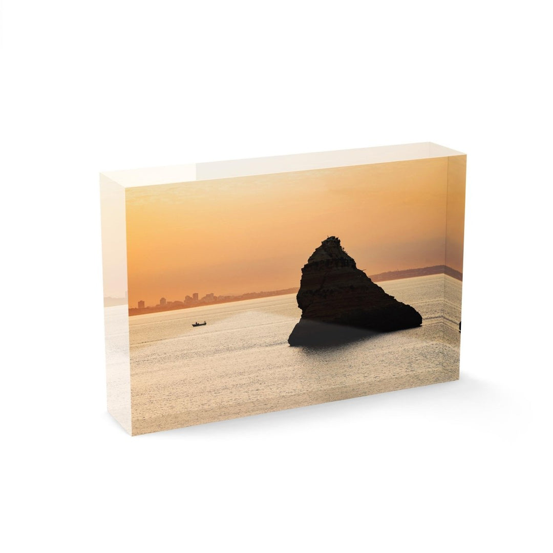 Large boulder and a fishing boat during Lagos sunrise