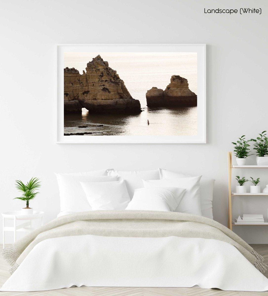 Man swimming during sunrise near large cliffs in Lagos in a white fine art frame