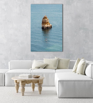Woman on a SUP paddling near big cliff in Lagos in an acrylic/perspex frame