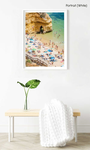 Stairway leading down to people, umbrellas, sand and green water on Camilo beach in a white fine art frame