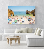 Busy Camilo beach with cliffs, people and calm green water in an acrylic/perspex frame