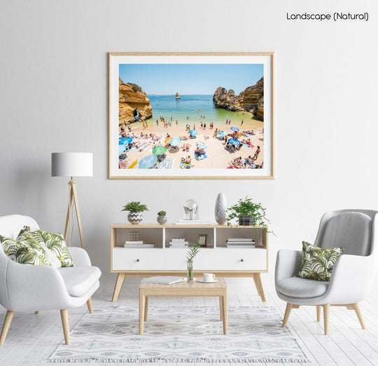 Busy Camilo beach with cliffs, people and calm green water in a natural fine art frame