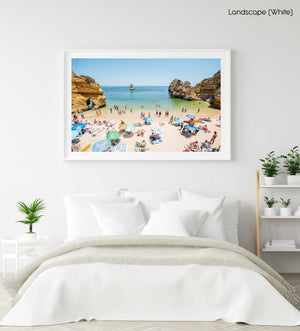 Busy Camilo beach with cliffs, people and calm green water in a white fine art frame
