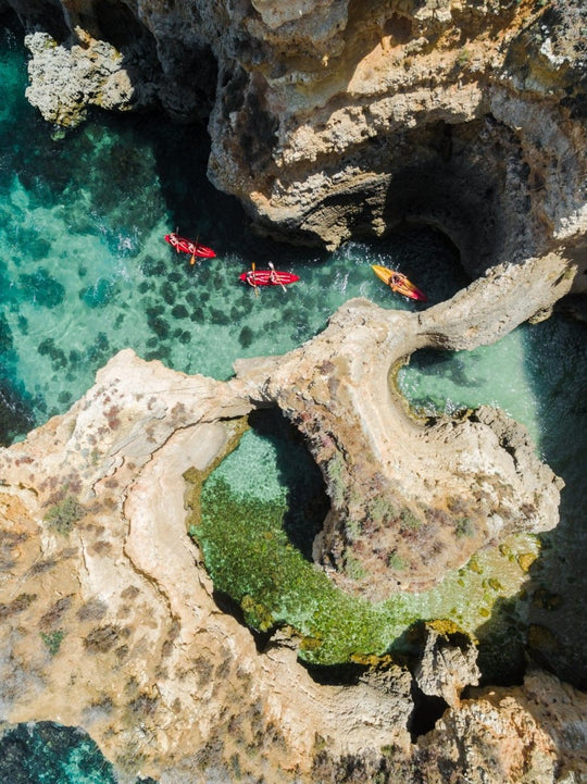 Three kayaks following each other through caves from above