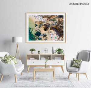 Aerial of a cave tunnel on Camilo Beach in Lagos with people on beach in a natural fine art frame