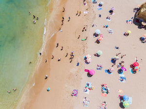 People enjoying sun and green water on Praia Dona Ana