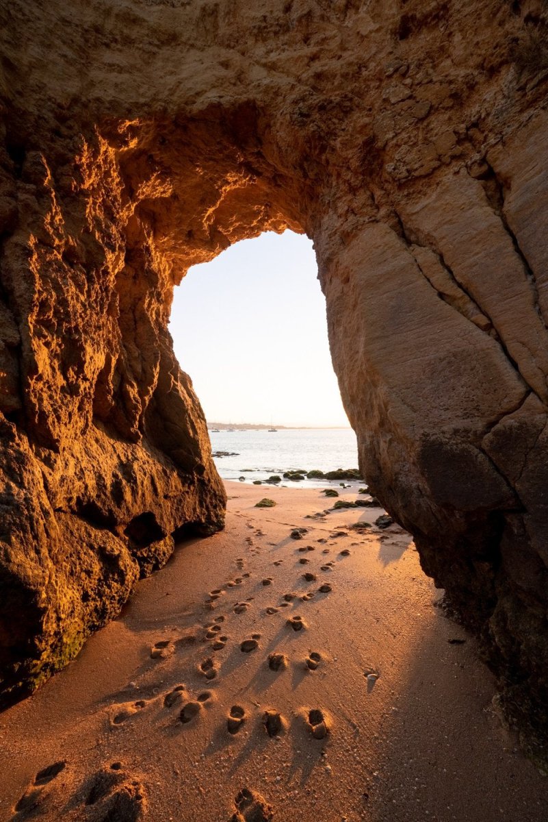 Golden orange light and footsteps through cave at Lagos