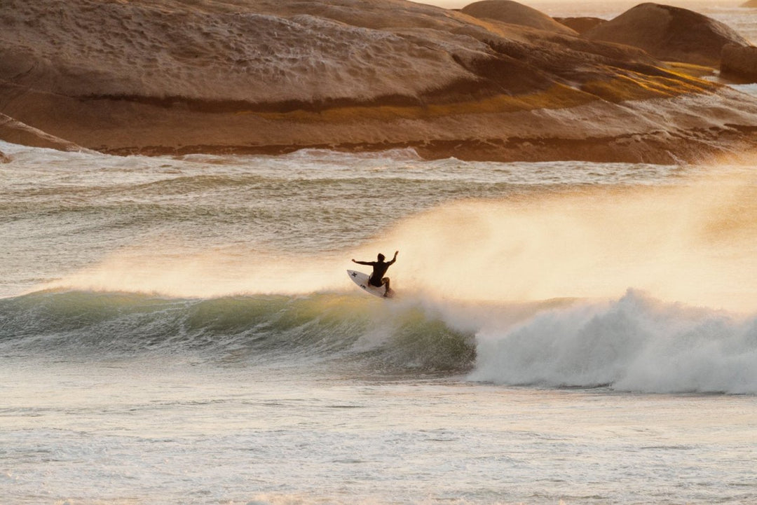 Surfer on a wave during sunset at Llandudno