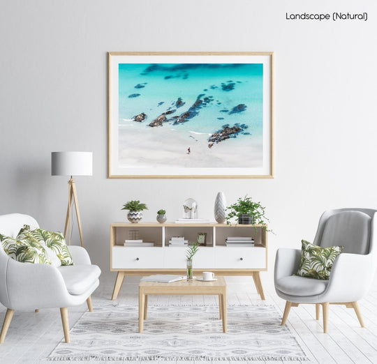 Person walking along crystal clear blue water at beach wall art